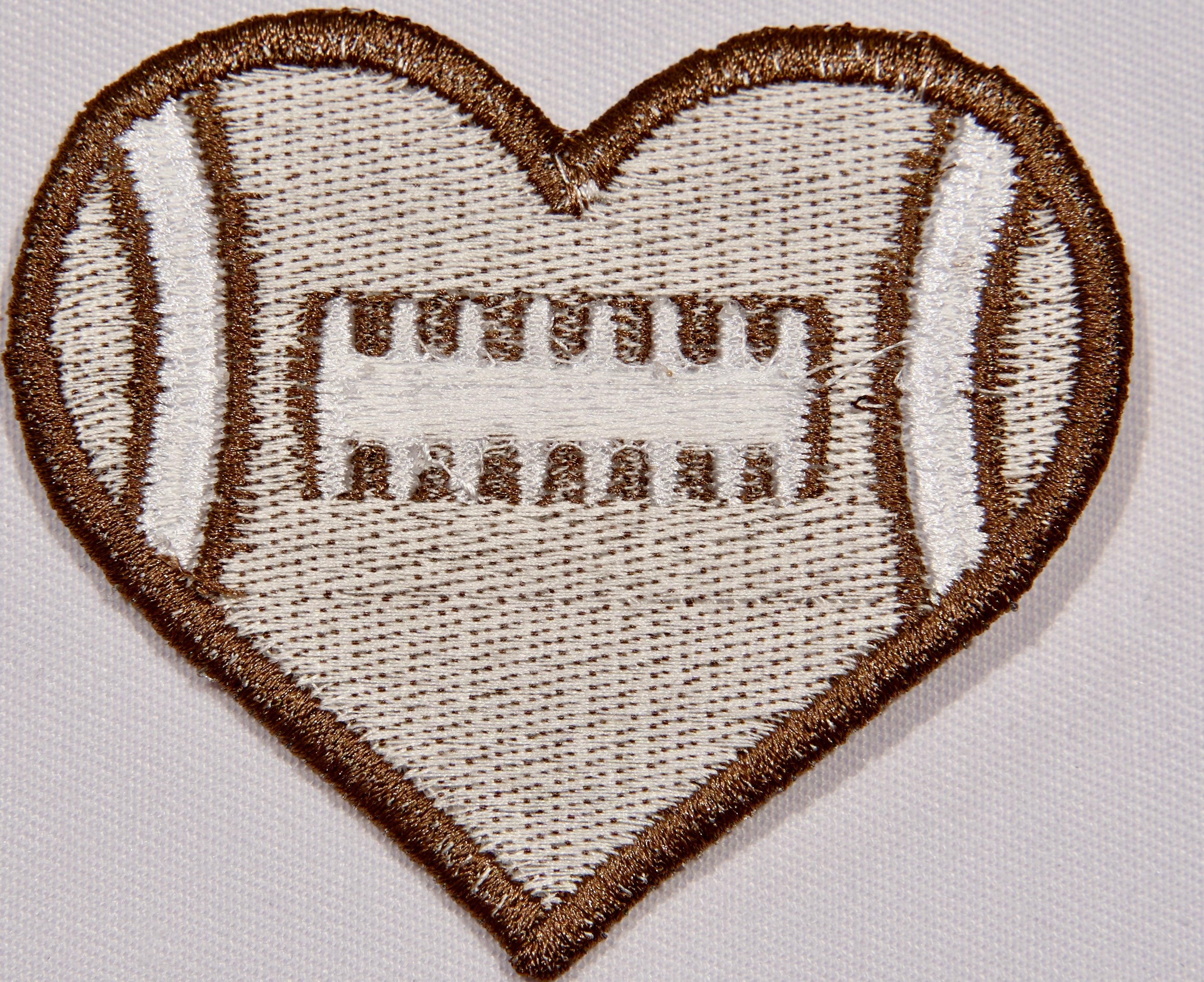 Back: a heart shaped embroidered patch with a football motif.