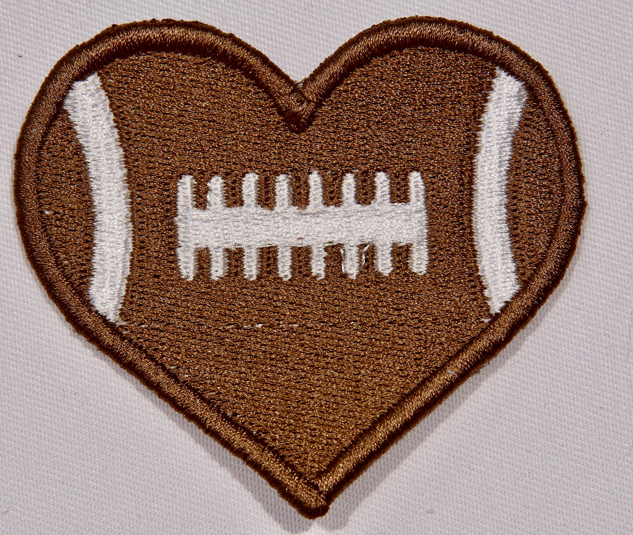 Front: a heart shaped embroidered patch with a football motif