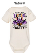 "Natural cream baby onesie with 'Just A Little Batty' purple bat wearing bowtie, skulls and small bats frame, candy corn colored letters, infant Halloween bodysuit"