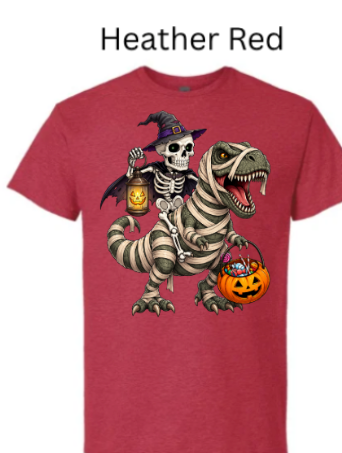 "Red heather t-shirt featuring skeleton witch on bandaged T-Rex back, glowing pumpkins, candy-filled bucket, mummy dinosaur with green eyes, Halloween trick-or-treating apparel"