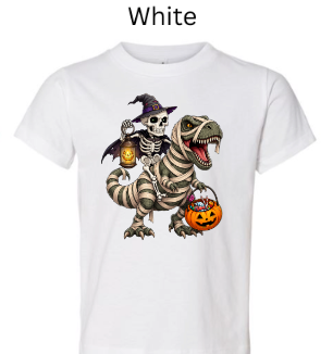 "White t-shirt featuring skeleton witch rider on mummy T-Rex, lantern lights, candy basket, big-eyed wrapped dinosaur, whimsical Halloween trick-or-treat design"